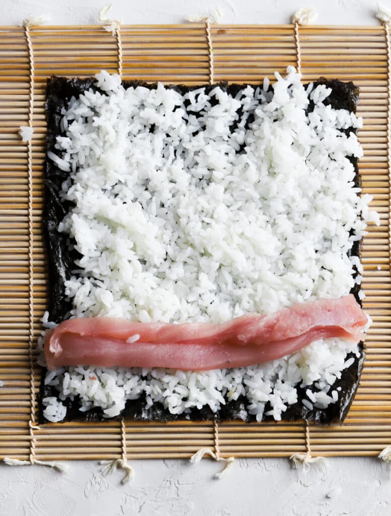 Adding the tuna on top of the rice