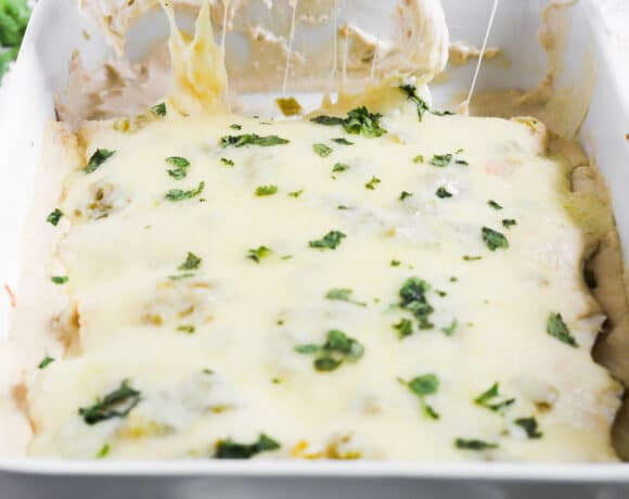 removing one white chicken enchilada from the casserole dish.