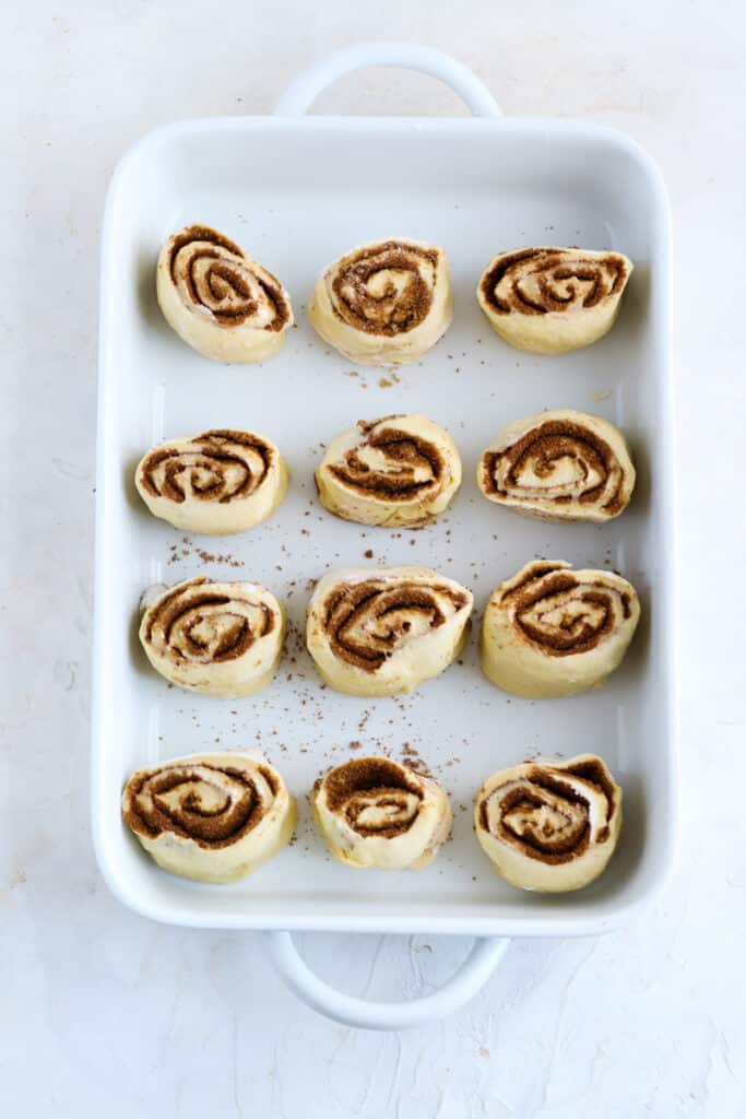 roll out the dough and add butter, cinnamon and brown sugar. Roll the dough and cut the cinnamon rolls