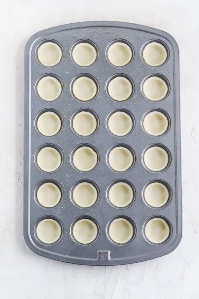 form the pie dough to the mini muffin tin